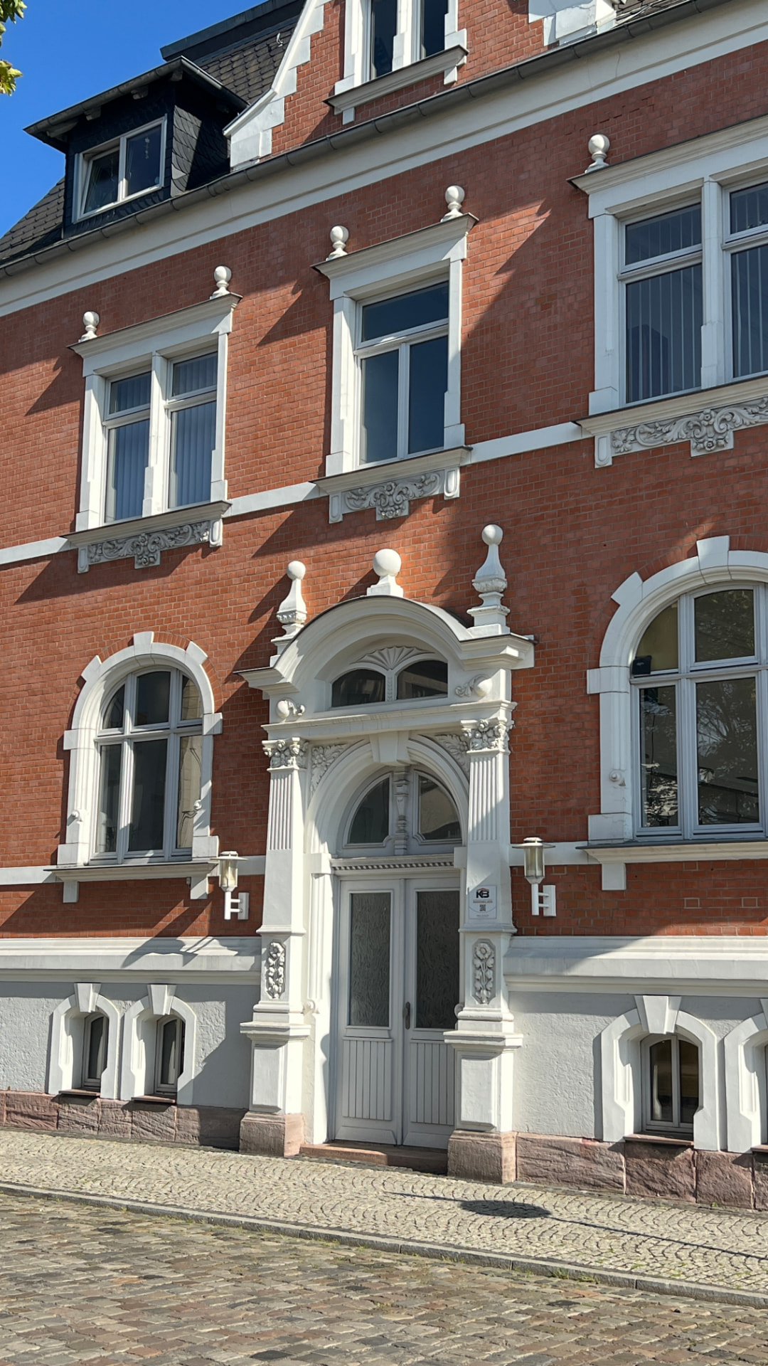 Hauptportal – Rundbogen, Voluten und Fialen in Sandstein